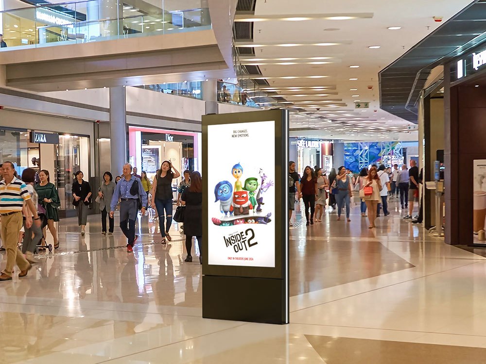 An indoor digital kiosk in a shopping mall showing advertising