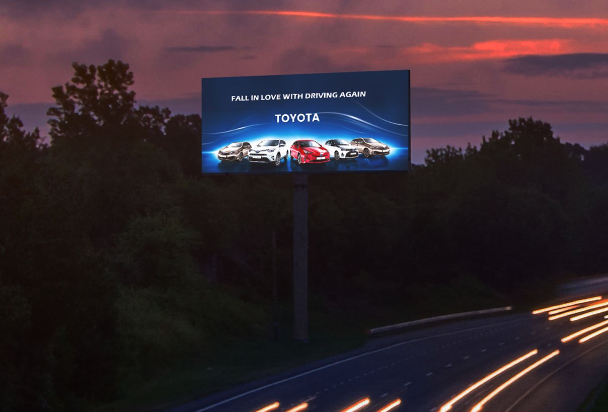 A large outdoor LED billboard beside a road