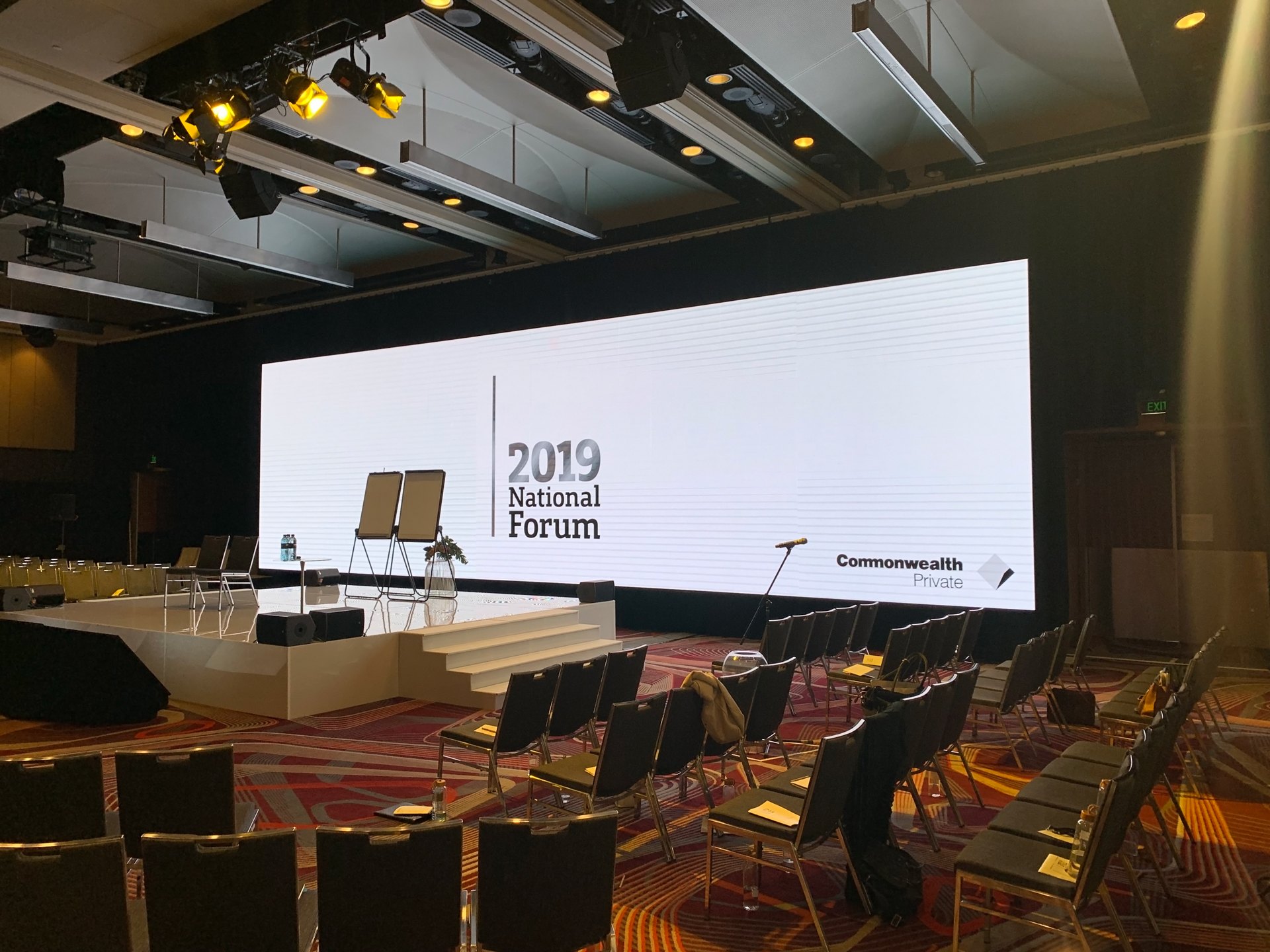 A corporate event stage backed by a hired LED display