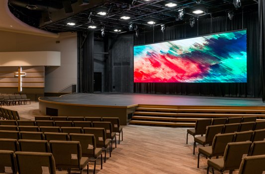 An LED video wall above the stage of a church auditorium